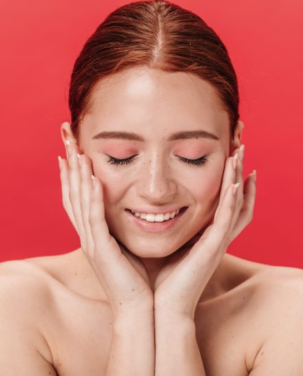 Shy woman smiling with closed eyes. Studio shot of ginger girl touching face on red background. SSUCv3H4sIAAAAAAAACnRSPW/DIBDdK/U/WMyxiu3Yxhk7dKvUrUPV4cCXGIVABDhVFOW/F/zRMrQb9+7uvXt33B4fsoxwcFKQXXaLUYilUqPzFrw0OsB0s+AWdY82RS62amgKYC+9sRJUCnLwYtBwwgDqUakI36ckcR786NBF9QUS4PEQOGbwh2Ie8WOOszUxJUNHSJFnhNFfn17ADXHwTVLhRh4rXqUTqBRoNKMja37W/Yf0Dc1Z4V9k7+aE+pdkfnyunuGAWlwnW4ldiwphtrs4IRTqigGr87psaL4VrMw7qHjOipZDuy+6LaOTykxNjl8e7SldGIy9NMmuLkaAigVVony2Ukh9SNqMH6Zjrm3CjNrbODJZ7RJlzBl48L/L9oETV3wA50J5v+KJkAhfx5wSHW38ZHhhJX24bwyLqmyatm7LoqhZx0paLgXznxhk4JnGWYlCLI6yT63LOAHhvG2Kumly3mKfb0tG8w57lm/3DcWCotiLNqzw/g0AAP//AwChcvR67gIAAA==